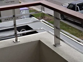 Close view of stainless steel balcony posts and timber handrail